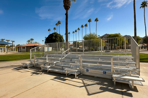 Metal bleachers on a concrete surface with palm trees in the background