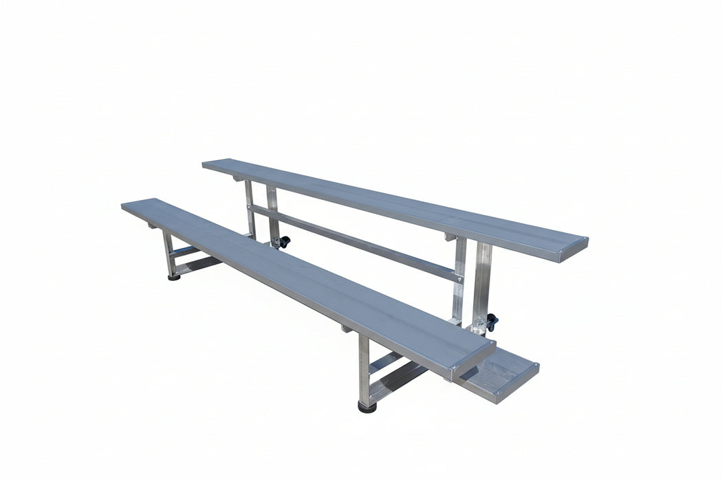 Two metal bleachers on a concrete floor with a warehouse in the background