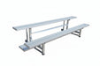 Aluminum bleachers on a concrete surface with a trailer in the background