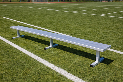 Long metal bench on a grassy sports field